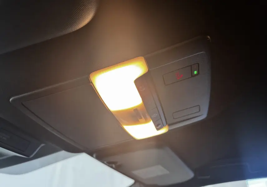 Plafonnier intérieur allumé avec commandes SOS et éclairage ambiant dans un Nissan Qashqai e-Power noir 2023.