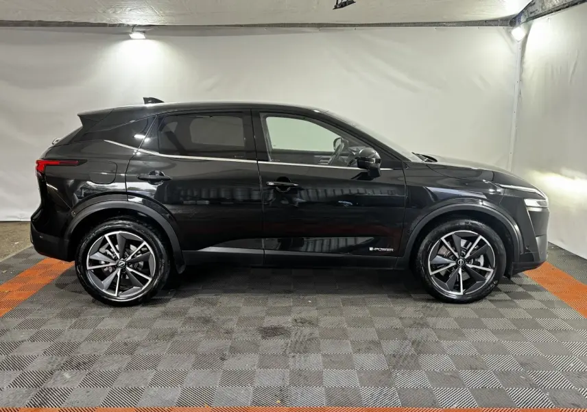 Vue de profil côté gauche du Nissan Qashqai e-Power 190 Tekna BVA noir avec jantes alliage et badge e-Power visible.