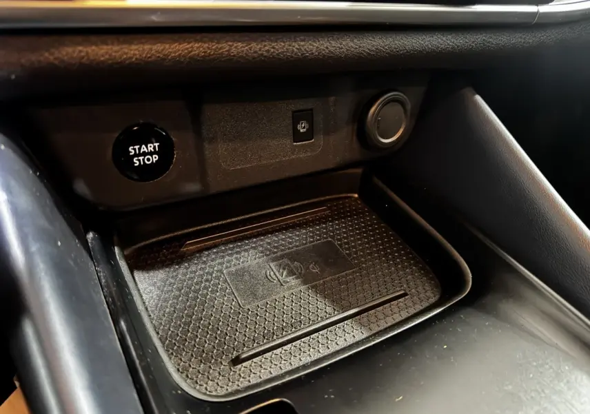 Gros plan sur la zone de recharge sans fil et bouton Start/Stop du Nissan Qashqai e-Power noir, intérieur avant.