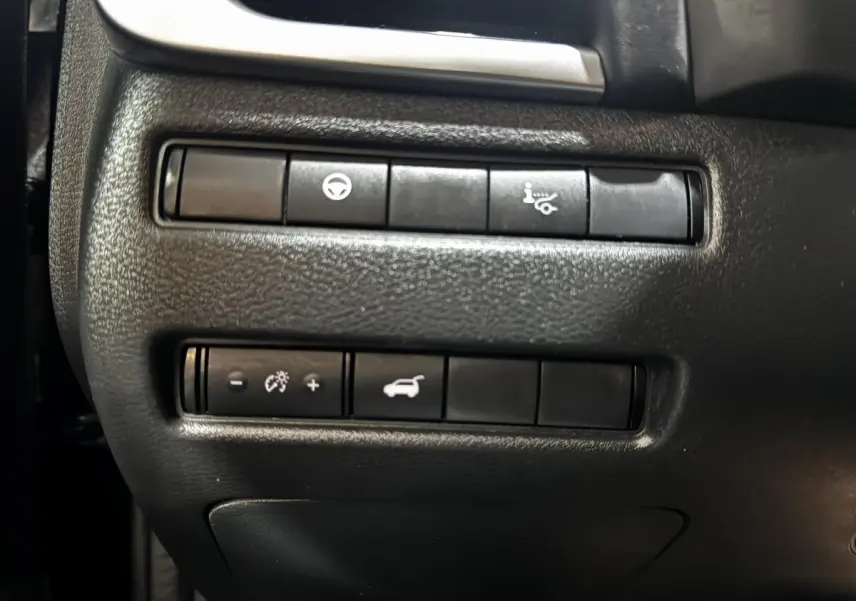 Gros plan sur les commandes de tableau de bord noir du Nissan Qashqai e-Power 190 Tekna BVA 2023, boutons fonctionnels visibles.