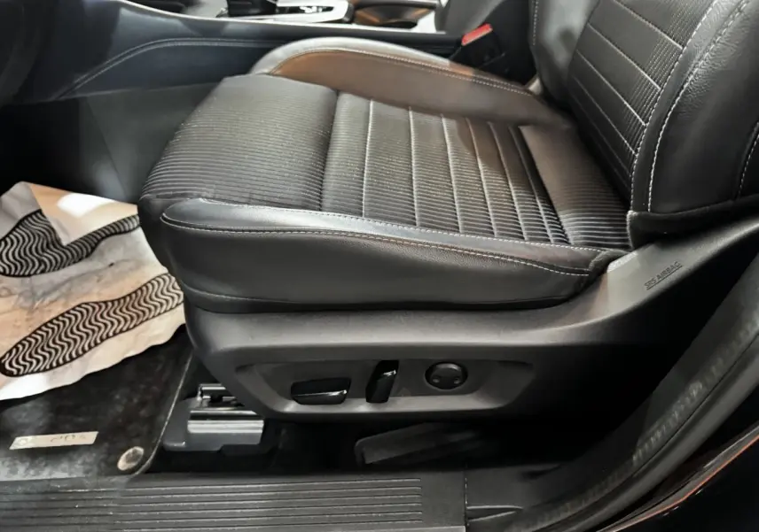 Gros plan sur le siège avant droit noir en cuir et tissu du Nissan Qashqai e-Power 2023 avec commandes électriques.