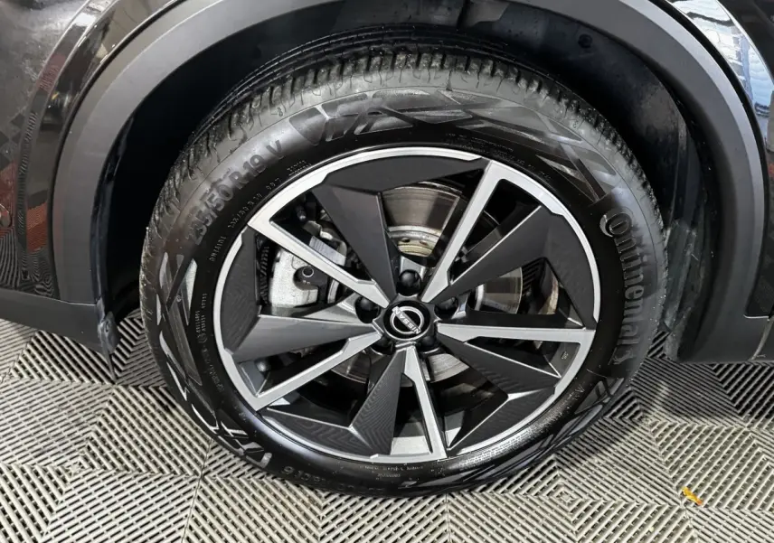 Gros plan sur la roue avant droite noire du Nissan Qashqai e-Power 190 Tekna BVA avec jante alliage distinctive.