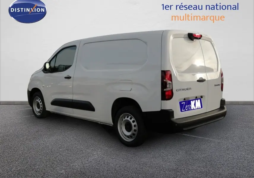 Vue 3/4 arrière droite d'un Citroën Berlingo XL blanc Icy utilitaire avec vitrage arrière teinté et protections noires.