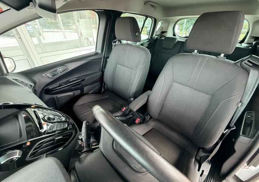 Intérieur avant du Ford B-MAX 2014 montrant les sièges en tissu gris et la console centrale noire brillante.