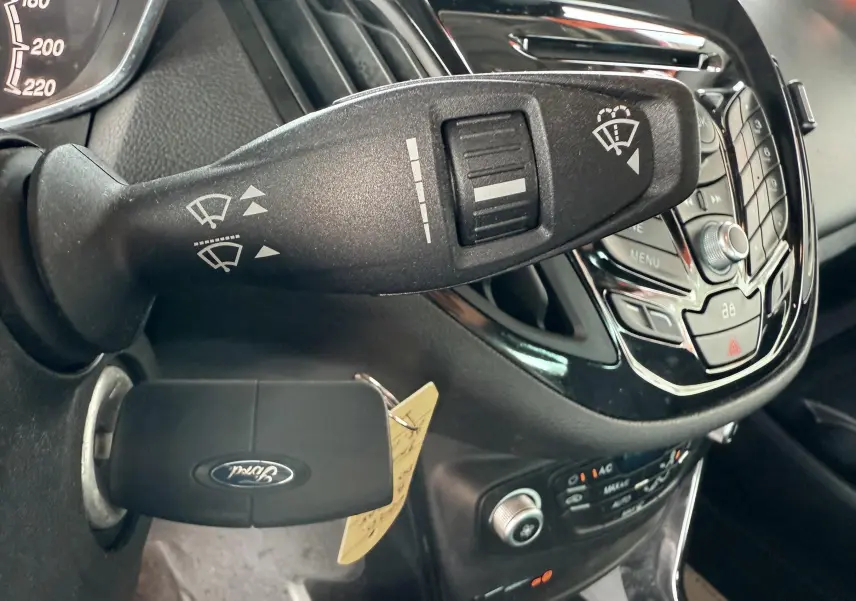 Gros plan sur la commande d’essuie-glace et la clé Ford insérée dans le contact d’un Ford B-MAX blanc, intérieur noir.
