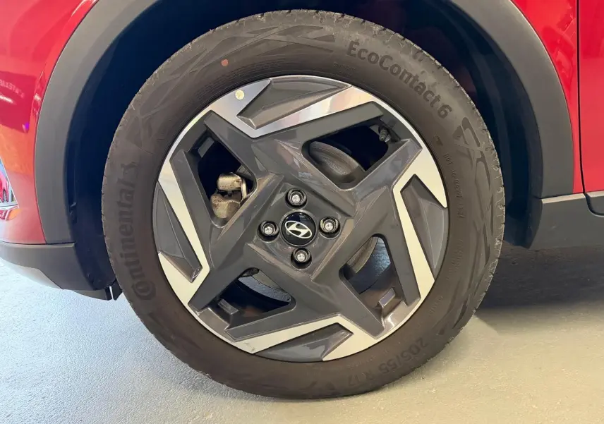 Gros plan sur la jante alu 17'' noire et argentée du côté avant gauche d'une Hyundai Bayon rouge.