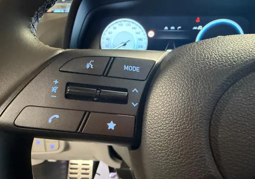 Gros plan sur les commandes du volant noir du Hyundai Bayon 2025, avec compteurs numériques en arrière-plan.