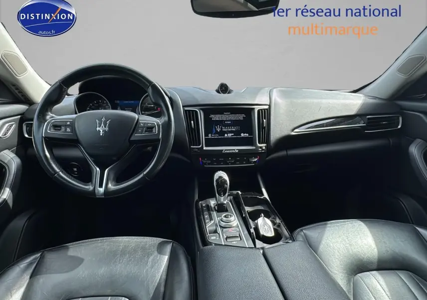 Intérieur noir du Maserati Levante 2017 vu de face, avec volant cuir et console centrale équipée d'un écran tactile.