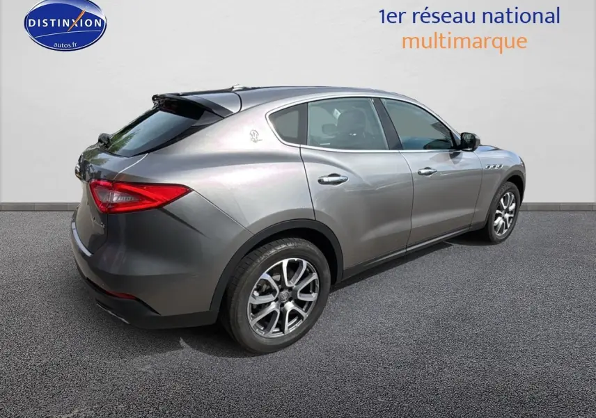 Vue 3/4 arrière droite d'un Maserati Levante gris métallisé avec jantes alliage et feux arrière LED.