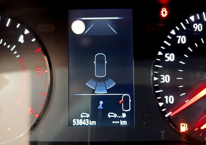 Affichage numérique du combiné d'instruments du Renault Kangoo 2022, montrant l'aide au stationnement et l'alerte porte ouverte.