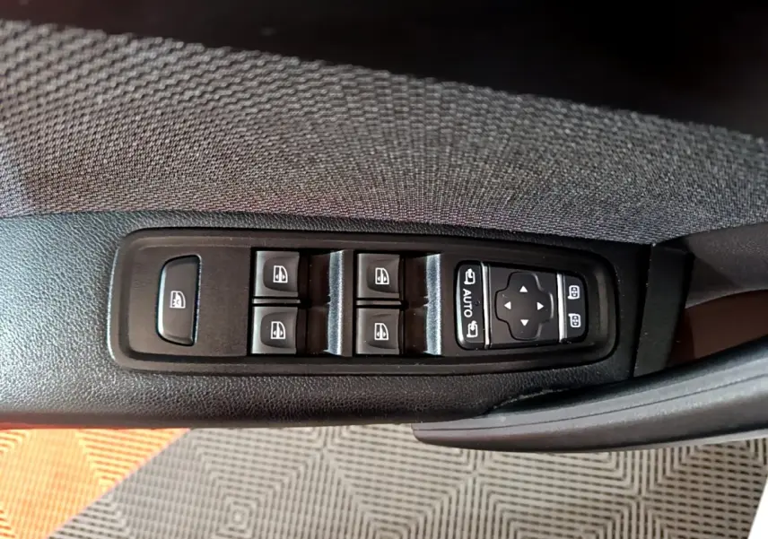 Gros plan sur les commandes de lève-vitres et réglage des rétroviseurs côté conducteur du Renault Kangoo blanc 2022.