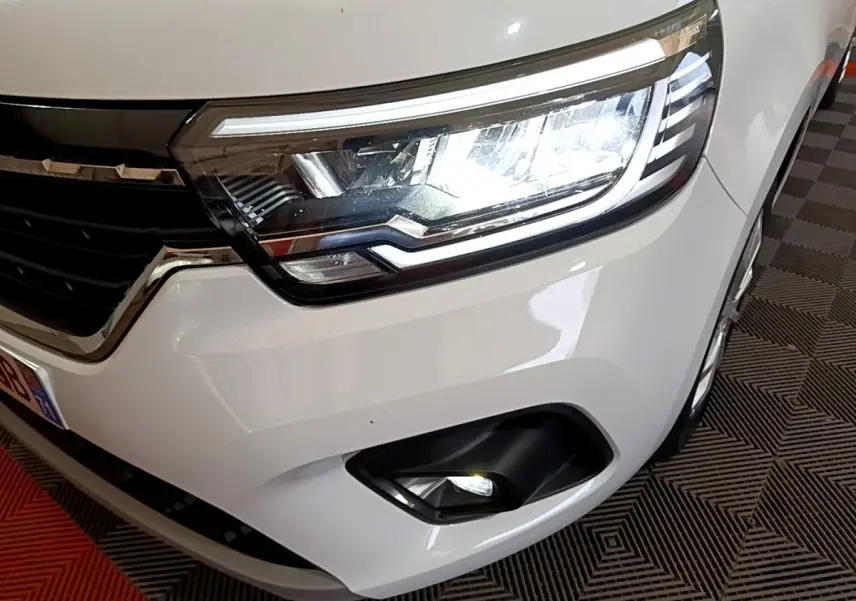 Gros plan sur le phare avant droit blanc du Renault Kangoo Equilibre 2022 avec antibrouillard et calandre noire.