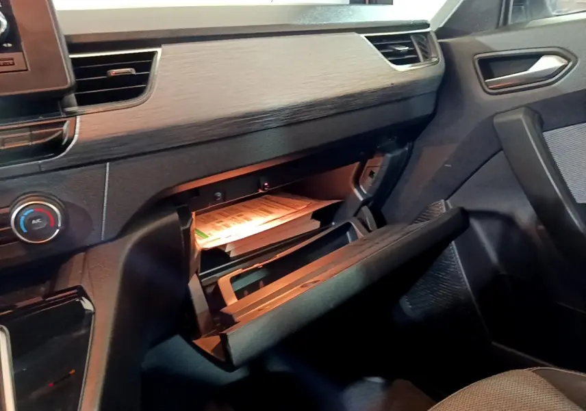 Intérieur du Renault Kangoo Equilibre 2022, vue côté passager sur la boîte à gants ouverte avec documents visibles.