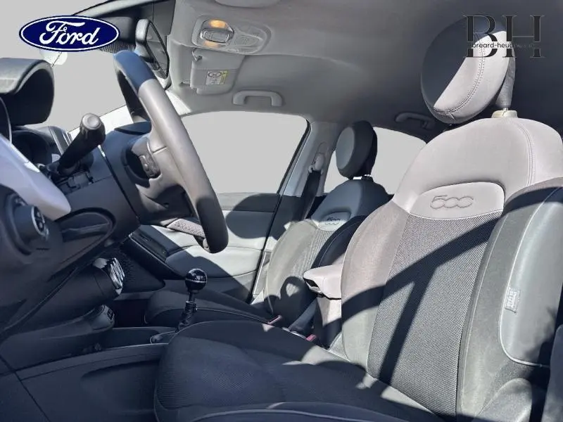 Vue intérieure côté conducteur de la FIAT 500X 2015, sièges tissu bi-color noir et gris avec logo 500 brodé.