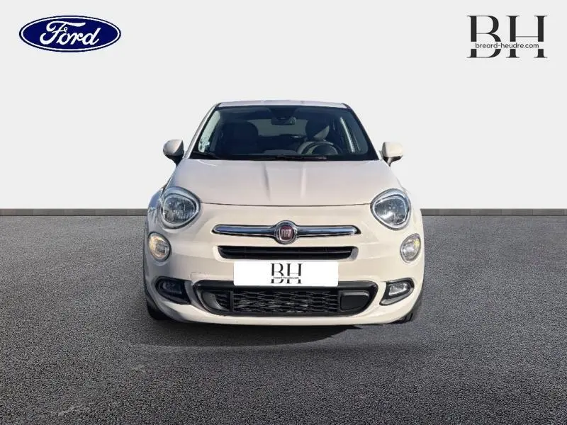 Vue avant d'une FIAT 500X argentée de 2015 avec phares ronds et calandre chromée distinctive.