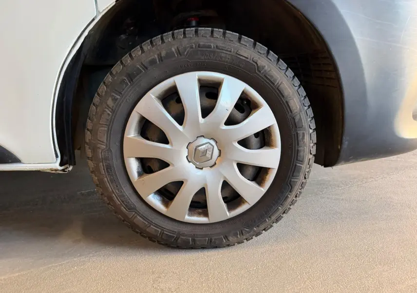 Gros plan sur la roue avant droite blanche d’un Renault Trafic Fourgon 2017 avec jante en plastique gris clair.