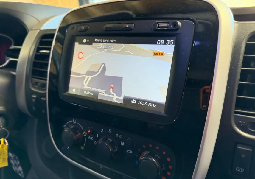 Gros plan sur le tableau de bord du Renault Trafic Fourgon 2017 avec écran GPS et commandes de climatisation.