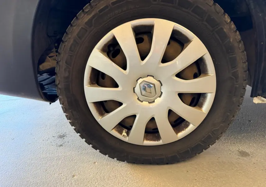 Gros plan sur la roue avant gauche du Renault Trafic Fourgon blanc, avec enjoliveur argenté et logo Renault central.
