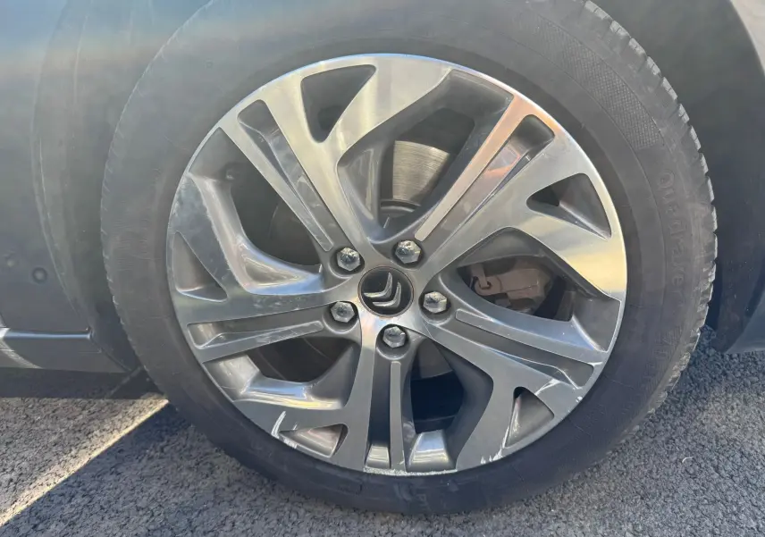 Gros plan sur la jante alu gris foncé d'une Citroën C4 Picasso 2016, mettant en valeur le logo Citroën central.