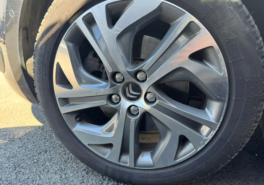 Gros plan sur la jante alu gris foncé d’une Citroën C4 Picasso 2016 avec logo Citroën au centre.