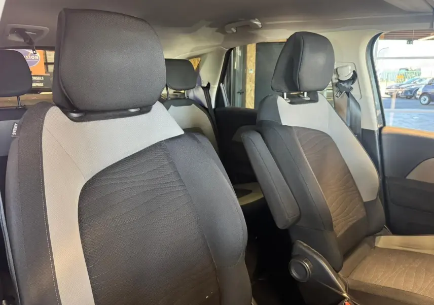 Vue intérieure des sièges avant en tissu noir et gris du Citroën C4 Picasso 2016, côté droit, avec appuie-bras et ceinture visible.
