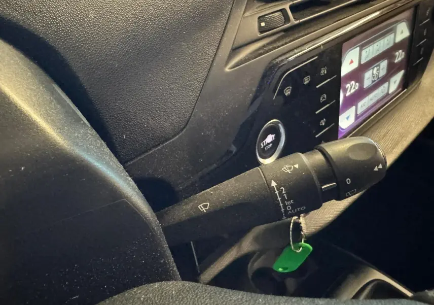 Gros plan intérieur sur la commande d’essuie-glace et le tableau de bord numérique d’une Citroën C4 Picasso 2016.