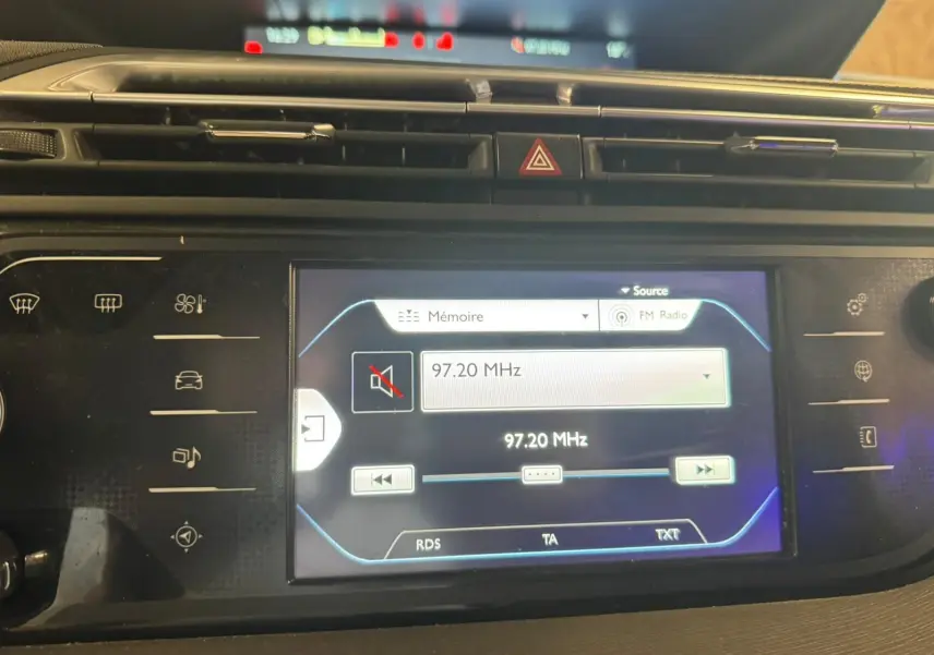 Vue rapprochée de l'écran tactile central du tableau de bord de la Citroën C4 Picasso 2016, affichant la radio FM.