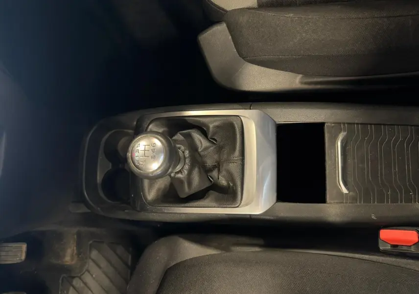 Vue intérieure centrée sur le levier de vitesse manuel en cuir noir de la Citroën C4 Picasso 2016, avec console centrale grise.