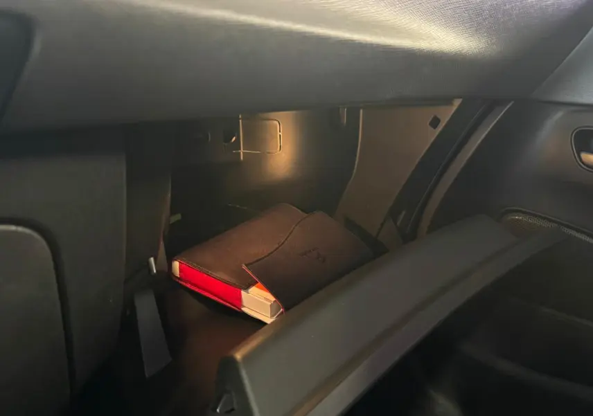 Vue intérieure du coffre à gants ouvert d'une Citroën C4 Picasso 2016, montrant un manuel dans une pochette noire.