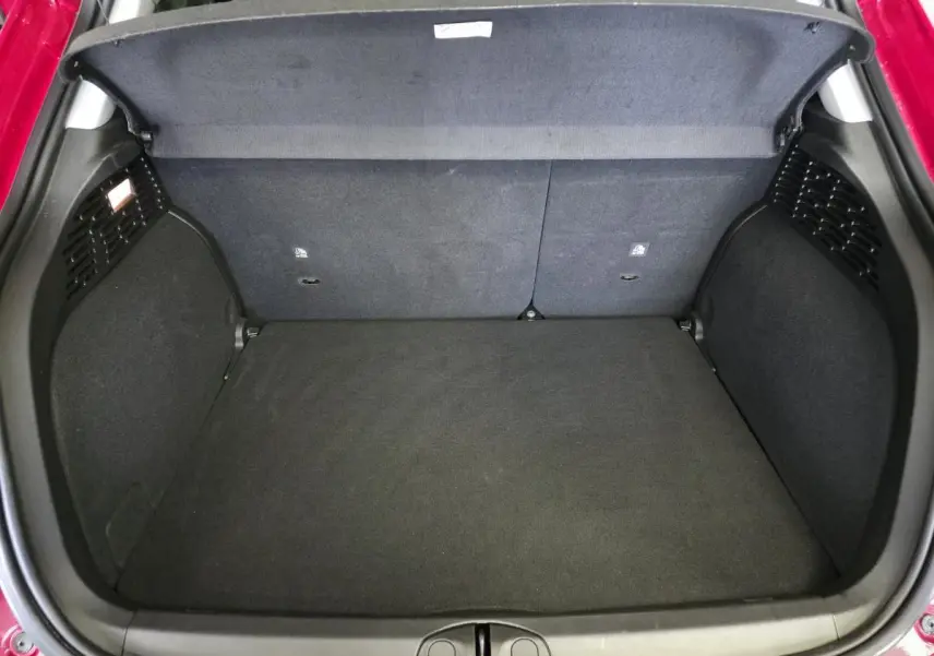 Coffre ouvert vu de dessus du Fiat 500X rouge, montrant un espace de chargement propre et vide.