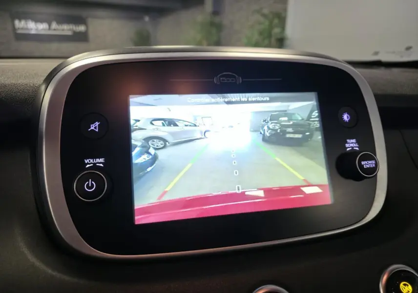 Écran multimédia affichant la caméra de recul d'une Fiat 500X rouge, vue intérieure centrée sur l'écran tactile.