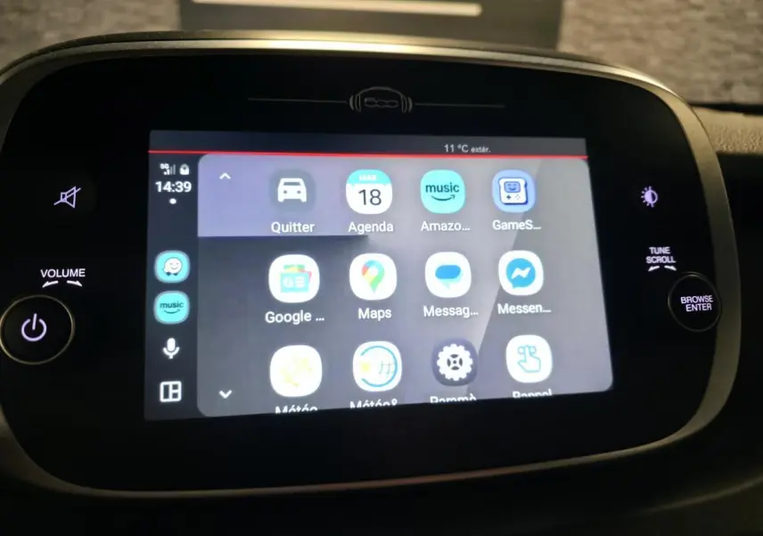 Écran tactile central de la Fiat 500X 2024 affichant les applications multimédia avec commandes autour en noir mat.
