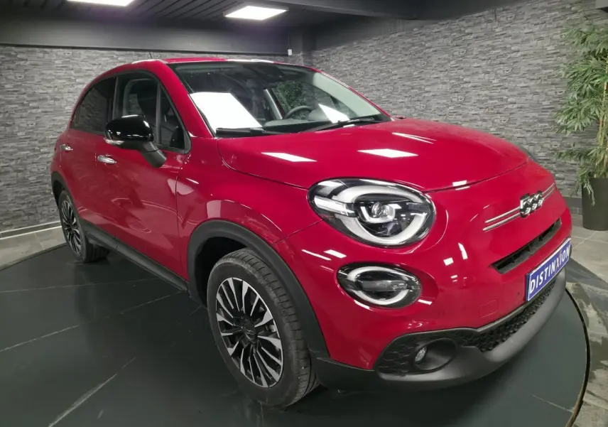 Fiat 500X rouge Passione en 3/4 avant droit, avec jantes alliage 17'' et coques de rétroviseurs noires.