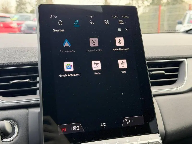 Écran tactile central du Renault Captur 2025 affichant les options multimédia, entouré de la planche de bord grise.