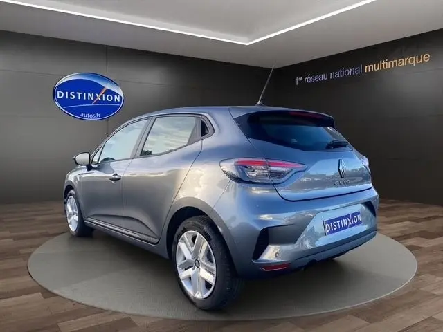 Vue 3/4 arrière droite d'une Renault Clio gris foncé 2025 avec feux LED et jantes alliage en showroom.