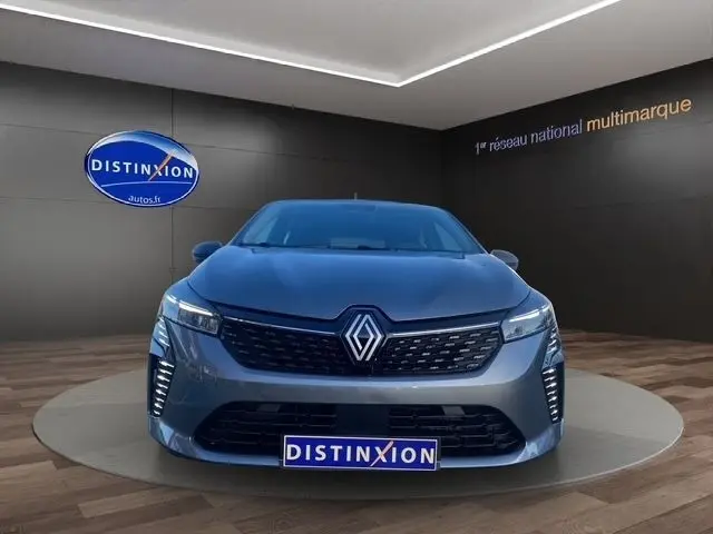 Vue frontale d'une Renault Clio Evolution Blue dCi 100 gris foncé avec feux LED et calandre noire en showroom.