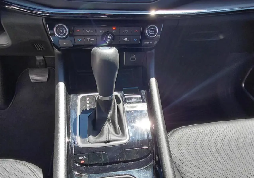 Vue rapprochée de la console centrale noire du Jeep Compass 2025, avec levier de vitesse automatique et commandes climatisation.