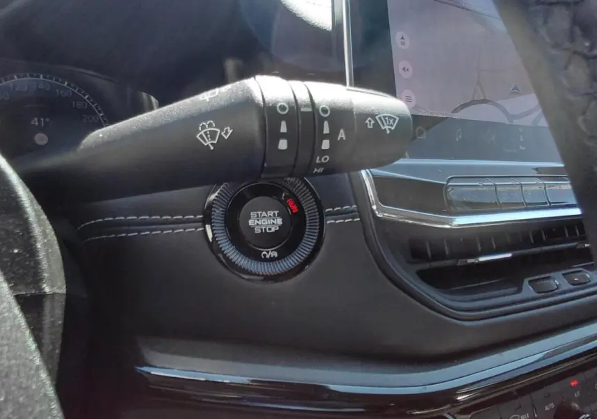 Gros plan intérieur sur le bouton Start Engine Stop et la commande d’essuie-glace du Jeep Compass 2025 noir.