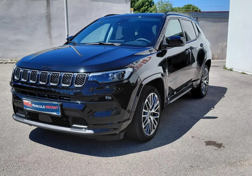Jeep Compass noir en 3/4 avant droit avec jantes alliage 19 pouces et barres de toit visibles en extérieur.