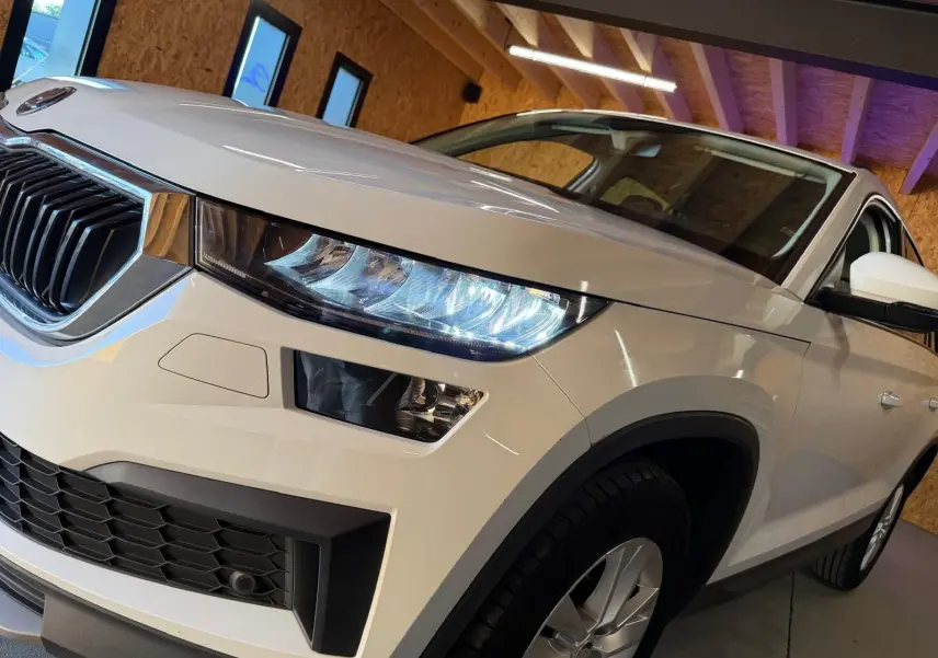 Vue du coffre du Skoda Kodiaq blanc 2023 montrant la roue de secours temporaire et les outils de changement de pneu.