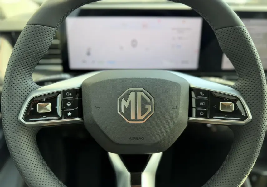Vue rapprochée du volant noir perforé de la MG MOTOR EHS 1.5 Hybrid+ 224 Luxury avec logo MG au centre.
