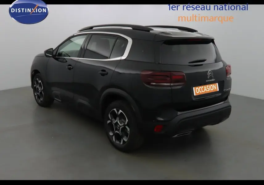 Profil côté gauche d'un Citroën C5 Aircross noir métal 2022 avec jantes biton et barres de toit visibles.