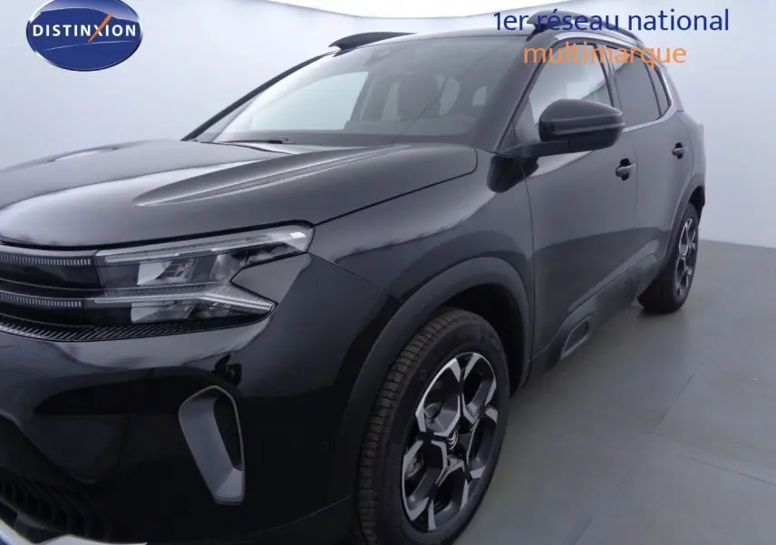 Vue 3/4 avant droite d'un Citroën C5 Aircross noir métal avec jantes bi-ton et phares LED distinctifs.