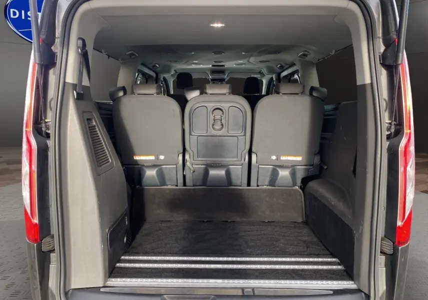 Vue arrière du Ford Tourneo Custom gris magnetic 2020 avec portes ouvertes et espace de chargement visible.