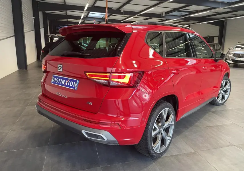 Vue 3/4 arrière droite d'un SEAT Ateca rouge 2022, version FR avec feux allumés et jantes alliage distinctives.