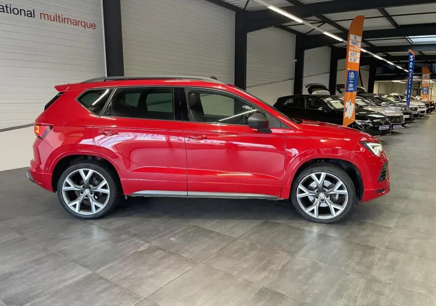 Vue de profil côté gauche d'un SEAT Ateca rouge 2022 version 2.0 TDI FR avec jantes alliage en concession.
