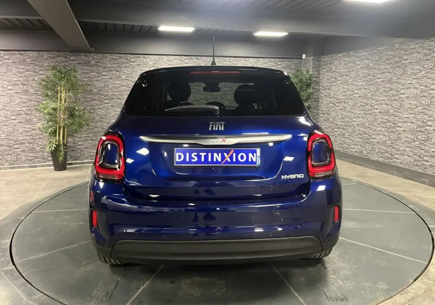 Vue arrière d'une Fiat 500X bleu métallisé avec feux LED distinctifs dans un showroom intérieur.