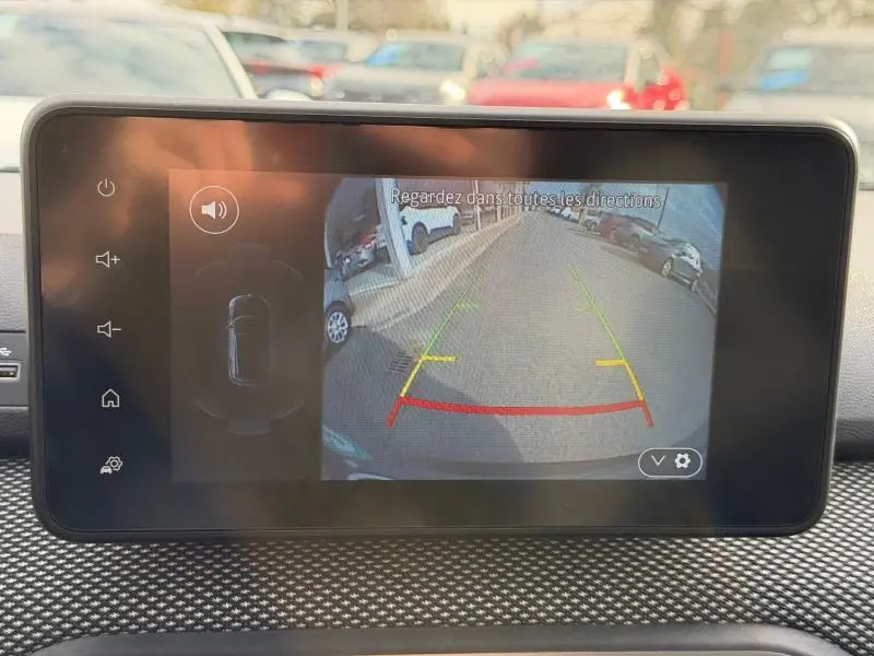 Écran intérieur montrant la caméra de recul du Dacia Jogger 2025 avec guidage coloré sur un parking extérieur.