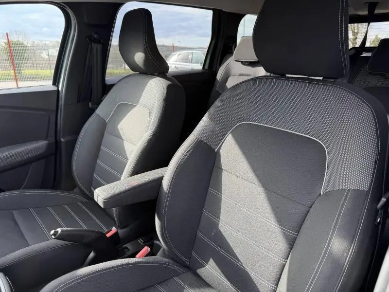Vue intérieure sur les sièges avant gris foncé du Dacia Jogger 2025, mettant en valeur l'accoudoir côté conducteur.