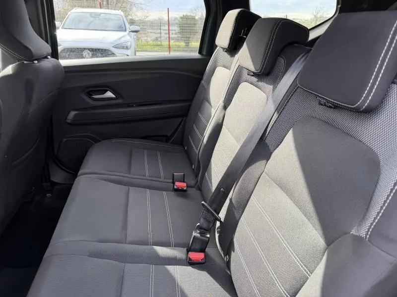 Vue intérieure des sièges arrière en tissu gris du Dacia Jogger 2025, côté droit, avec ceinture de sécurité attachée.